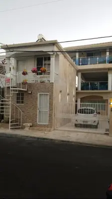 a house on the side of a street with a car parked in front at 2 Guests 1bed Studio 3min To Beach And Main Street in Sosúa