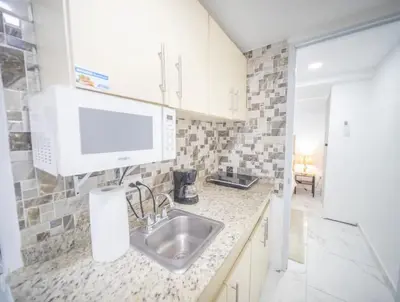 a kitchen with a sink and a tv on the wall at 2 Guests 1bed Studio 3min To Beach And Main Street in Sosúa
