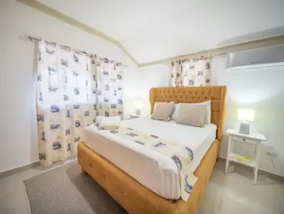 a bedroom with a large bed with a wooden headboard at Charming 1b Apto Walk To The Beaches Main Street in Sosúa