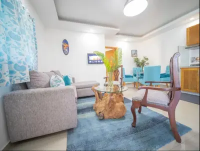 a living room with a couch and a table at Charming 1b Apto Walk To The Beaches Main Street in Sosúa