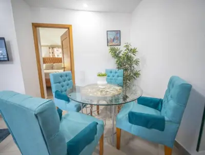 a dining room with blue chairs and a glass table at Charming 1b Apto Walk To The Beaches Main Street in Sosúa