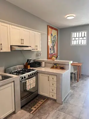 a kitchen with white cabinets and a stove top oven at Casa Lambí in Cabrera