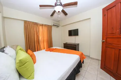 a bedroom with a bed and a ceiling fan at Acuarium Suite Resort in Santo Domingo