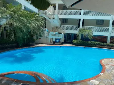 a large blue swimming pool in front of a building at Acuarium Suite Resort in Santo Domingo