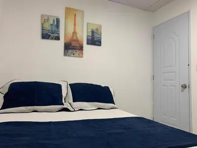 a bedroom with a bed with three pictures on the wall at Malecon Cozy Private Room 6 in Santo Domingo
