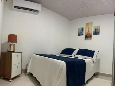 a bedroom with a bed with a blue blanket and a fan at Malecon Cozy Private Room 6 in Santo Domingo