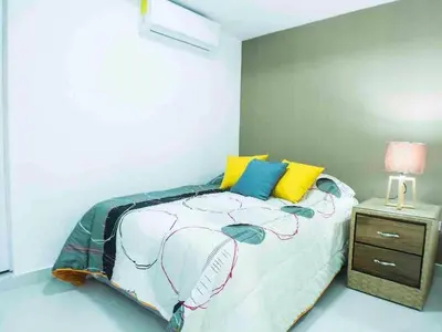 a bedroom with a bed and a night stand at Malecon Cozy Private Room 6 in Santo Domingo