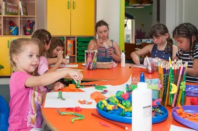 a group of children sitting at a table making crafts at Royalton Splash Punta Cana, An Autograph Collection All-Inclusive Resort & Casino in Punta Cana
