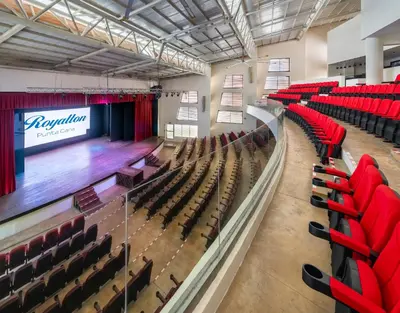 an empty auditorium with red chairs and a stage at Royalton Punta Cana, An Autograph Collection All-Inclusive Resort & Casino in Punta Cana
