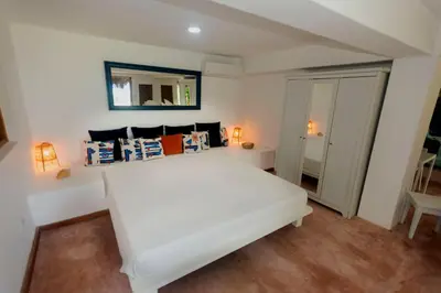 a bedroom with a white bed and a mirror at Studio Lotte - Ocean Front in Las Galeras