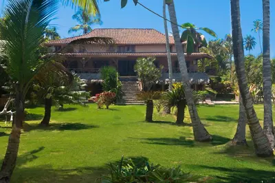 a house in the middle of a yard with palm trees at Studio Lotte - Ocean Front in Las Galeras