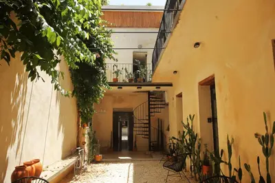 an alleyway with a staircase in a building with plants at FIXIE LOFTS - Colonial Villa Suites with Pool in Santo Domingo
