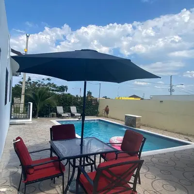 a table with chairs and an umbrella next to a pool at 2bedroom mountain view villa #2 in Muñoz