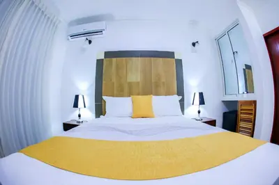 a bedroom with a large bed with a yellow blanket at Hotel Vicentina in Boca Chica