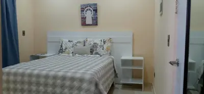 a bedroom with a bed with a laptop on it at Apartahotel MACADANA in Nagua