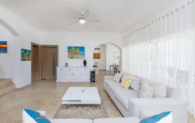 a living room with a white couch and a table at Luxury & Modern Villa with Pool at Cocotal Golf & Country Club in Punta Cana