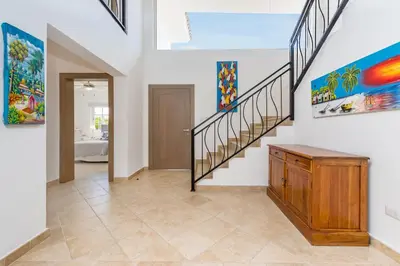 a hallway with stairs and paintings on the walls at Luxury & Modern Villa with Pool at Cocotal Golf & Country Club in Punta Cana