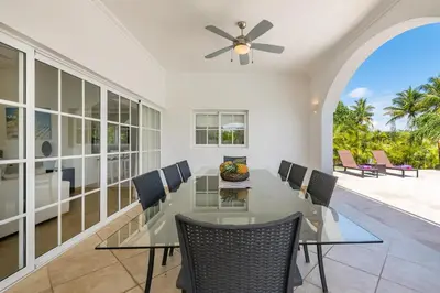 a dining room with a glass table and chairs at Luxury & Modern Villa with Pool at Cocotal Golf & Country Club in Punta Cana
