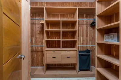 a walk in closet with wooden cabinets and a door at Unique Private Villa with Pools and Golf Cart in La Romana