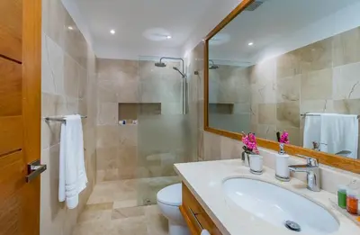 a bathroom with a sink and a toilet and a mirror at Unique Private Villa with Pools and Golf Cart in La Romana