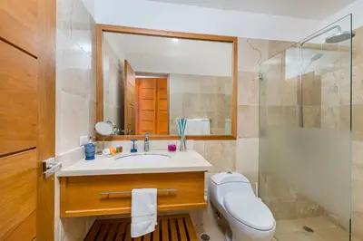 a bathroom with a toilet and a sink and a shower at Unique Private Villa with Pools and Golf Cart in La Romana