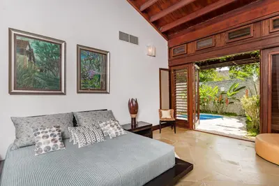 a bedroom with a bed and a sliding glass door at Unique Villa with Ocean and River Views - Staff & Golf Carts in La Romana