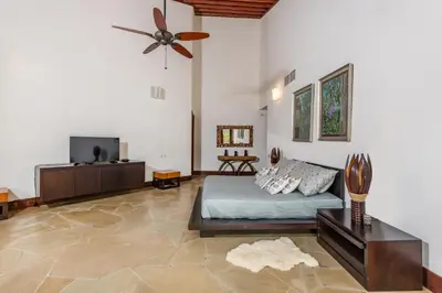a bedroom with a bed and a flat screen tv at Unique Villa with Ocean and River Views - Staff & Golf Carts in La Romana