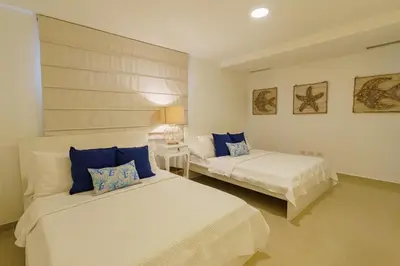 a bedroom with two beds with blue pillows at Luxury penthouse portobello in Santo Domingo