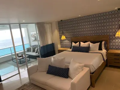 a bedroom with a large bed and a couch at Luxury penthouse portobello in Santo Domingo