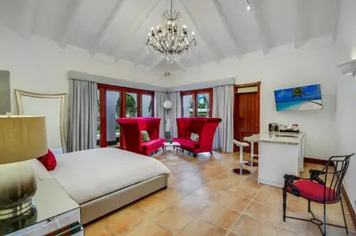 a bedroom with a bed and a table and chairs at Moroccan-Style Paradise with Pool & Maid at Casa de Campo in La Romana