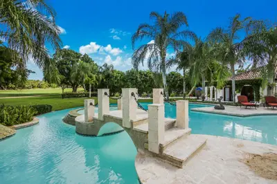 a pool at a resort with palm trees at Moroccan-Style Paradise with Pool & Maid at Casa de Campo in La Romana