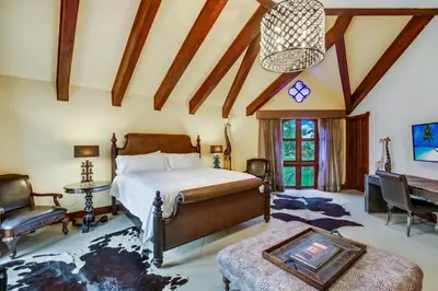 a bedroom with a bed and a table and a couch at Moroccan-Style Paradise with Pool & Maid at Casa de Campo in La Romana
