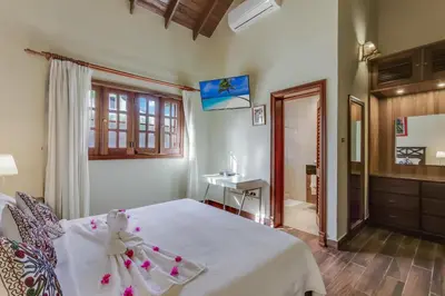 a bedroom with a white bed and a desk at Beautiful Villa with Pool, Gym & Maid in Punta Cana