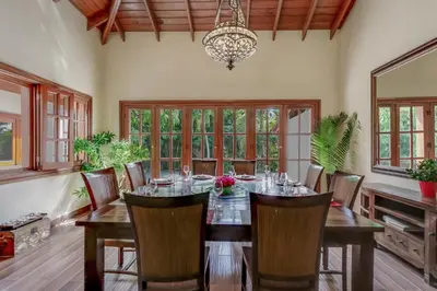 a dining room with a table and chairs and a chandelier at Beautiful Villa with Pool, Gym & Maid in Punta Cana