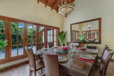 a dining room with a table and chairs and a mirror at Beautiful Villa with Pool, Gym & Maid in Punta Cana