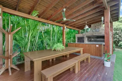 a wooden patio with a table and a fireplace at Beautiful Villa with Pool, Gym & Maid in Punta Cana