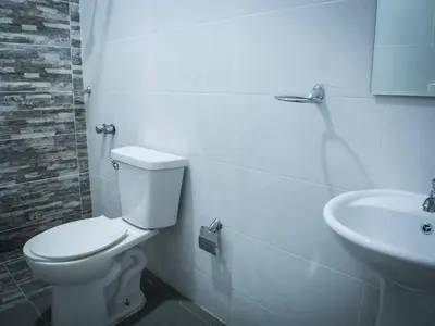 a bathroom with a toilet and a sink at Malecon Premium Rooms in Santo Domingo