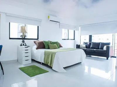 a white bedroom with a large bed and a couch at Malecon Cozy - Premium Plus 19 in Santo Domingo