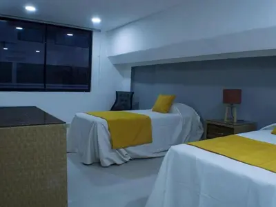 a bedroom with two beds with yellow sheets and a window at Malecon Cozy - Premium Plus 10 in Santo Domingo