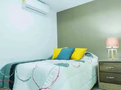 a bedroom with a bed with yellow and blue pillows at Malecon Cozy - Premium Plus 16 in Santo Domingo
