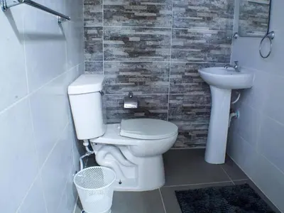 a bathroom with a toilet and a sink at Malecon Cozy - Premium Plus 4 in Santo Domingo