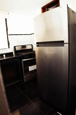 a stainless steel refrigerator in a kitchen with a stove at Residenciales H1 & H2 - Breakfast & Room Service - Airport close in Santiago de los Caballeros