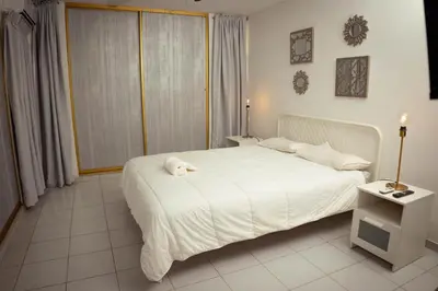 a bedroom with a white bed with a stuffed animal on it at Residenciales H1 & H2 - Breakfast & Room Service - Airport close in Santiago de los Caballeros