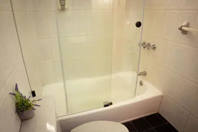 a bathroom with a shower and a toilet and a tub at Residenciales H1 & H2 - Breakfast & Room Service - Airport close in Santiago de los Caballeros