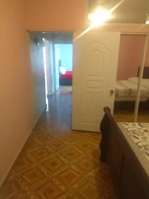 a hallway with a room with a bed and a door at Caribean House in Boca Chica