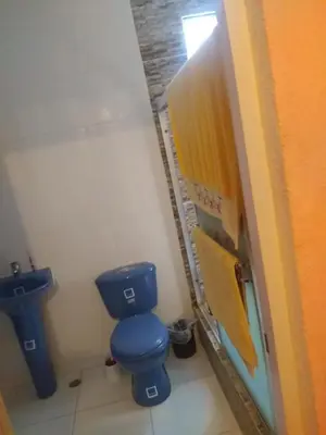 a bathroom with a blue toilet in a stall at Caribean House in Boca Chica