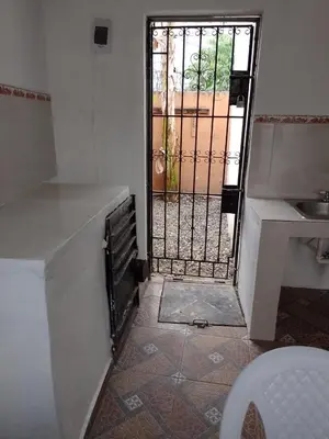 a bathroom with a door with a gate and a toilet at Caribean House in Boca Chica
