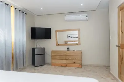 a room with a television and a dresser with a mirror at Verde Bonavita in Santiago de los Caballeros