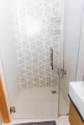 a shower with a glass door in a bathroom at Verde Bonavita in Santiago de los Caballeros