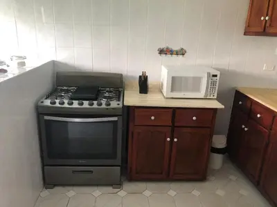 a kitchen with a stove and a microwave at La Gaviota A3 in Juan Dolio